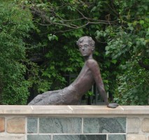 Statue of man sitting on wall
